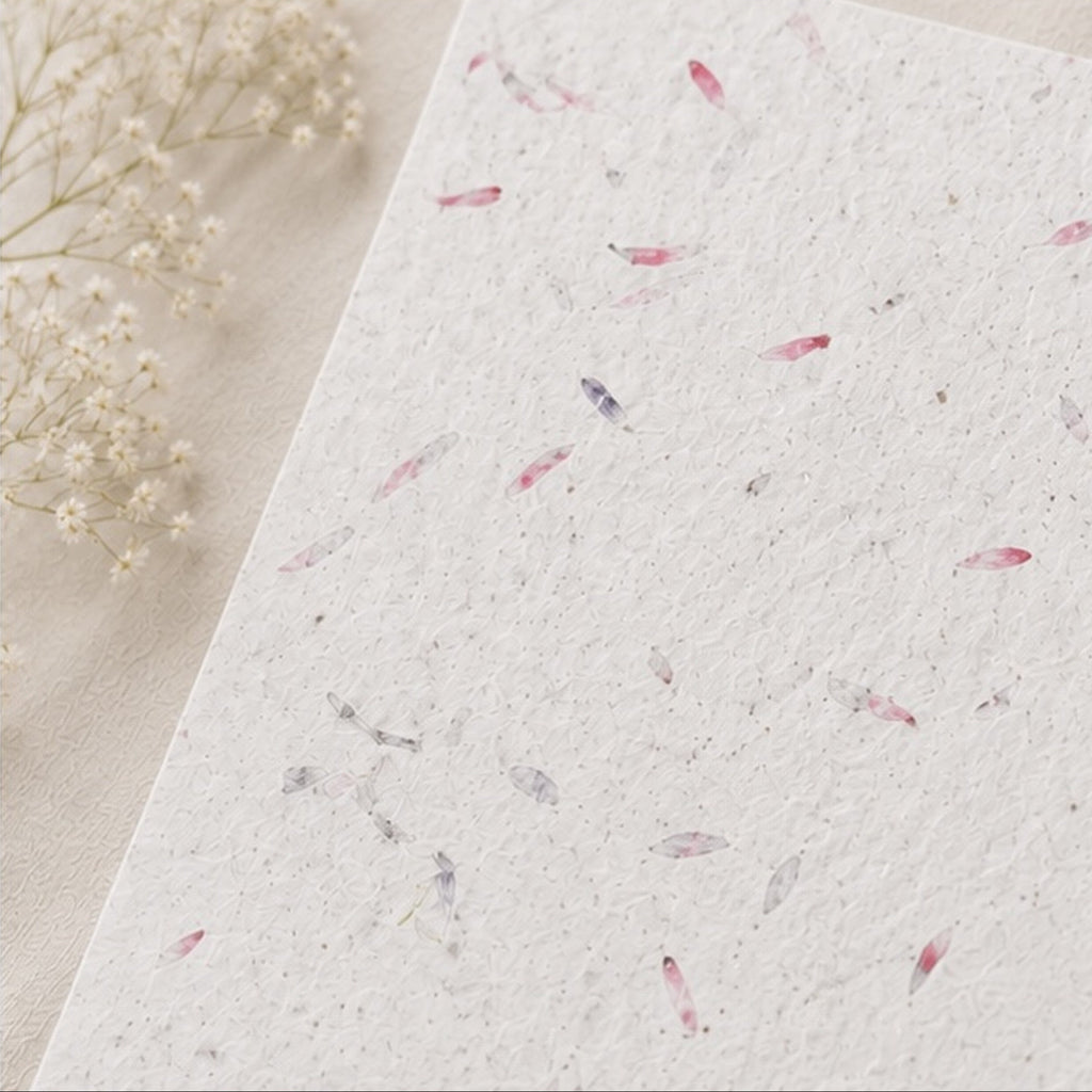 Close up of handmade pink petal seed paper texture with embedded wildflower seeds