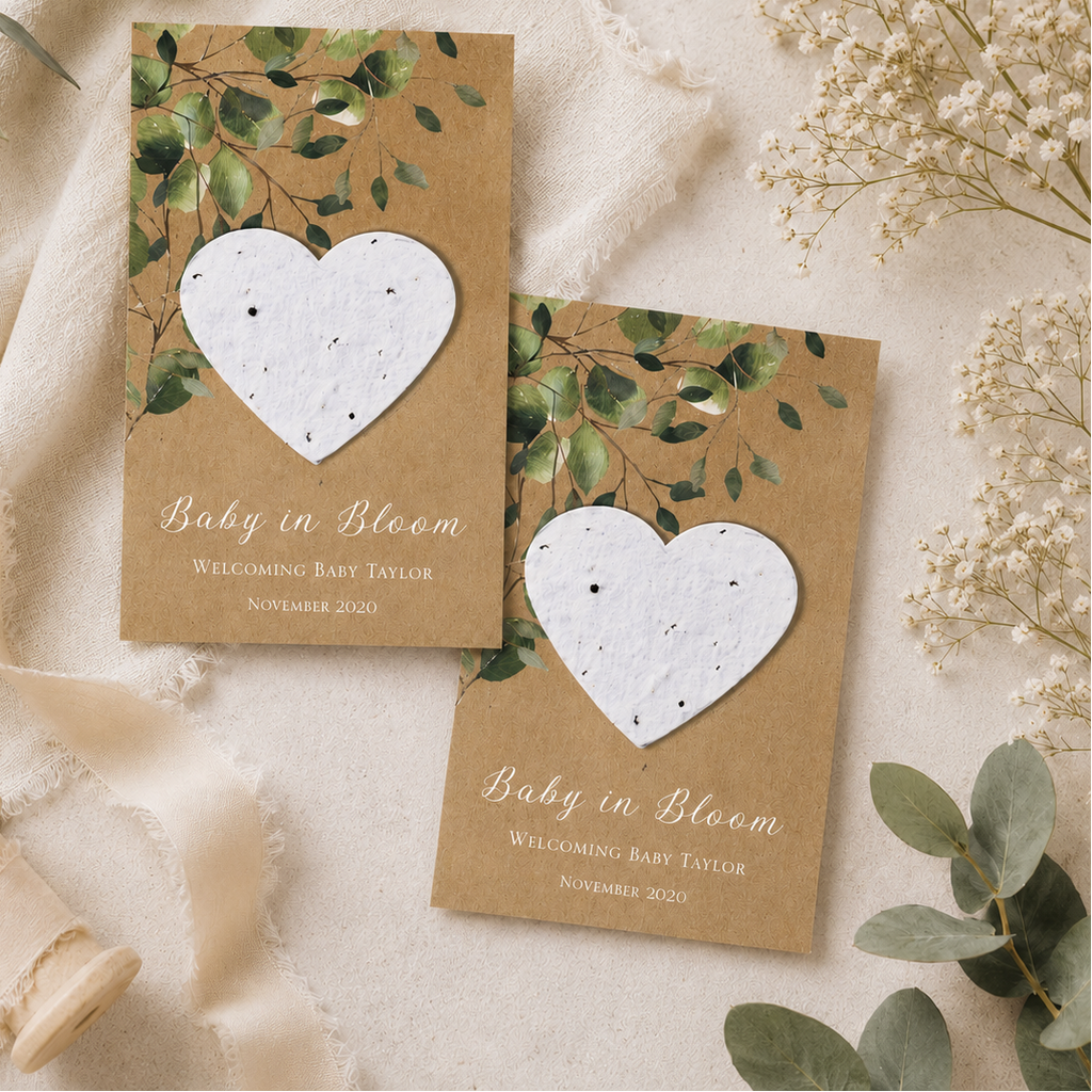 Eco-friendly baby shower favours featuring personalised cards with handmade plantable wildflower seed paper hearts, displayed as a natural guest gift idea.