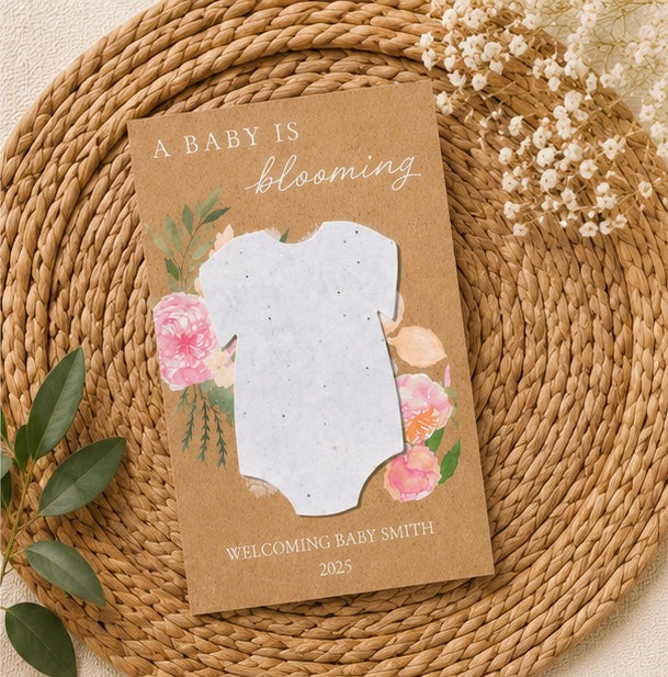 Eco-friendly baby shower favours featuring handmade plantable paper shapes with wildflower seeds and personalised event details.